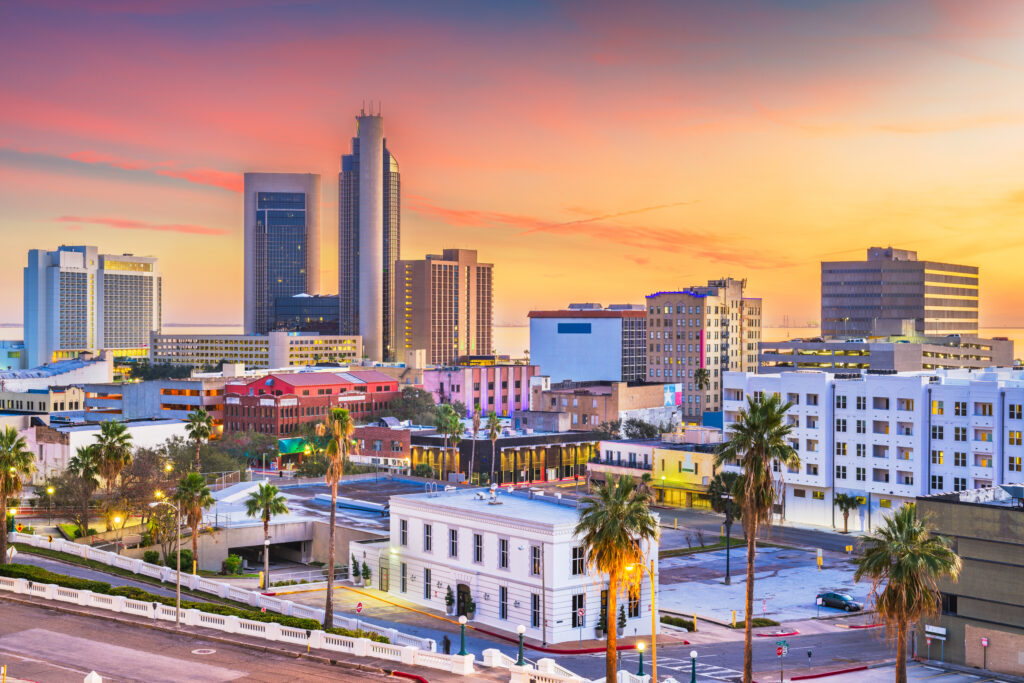 A photo of downtown Corpus Christi while the sun sets behind.